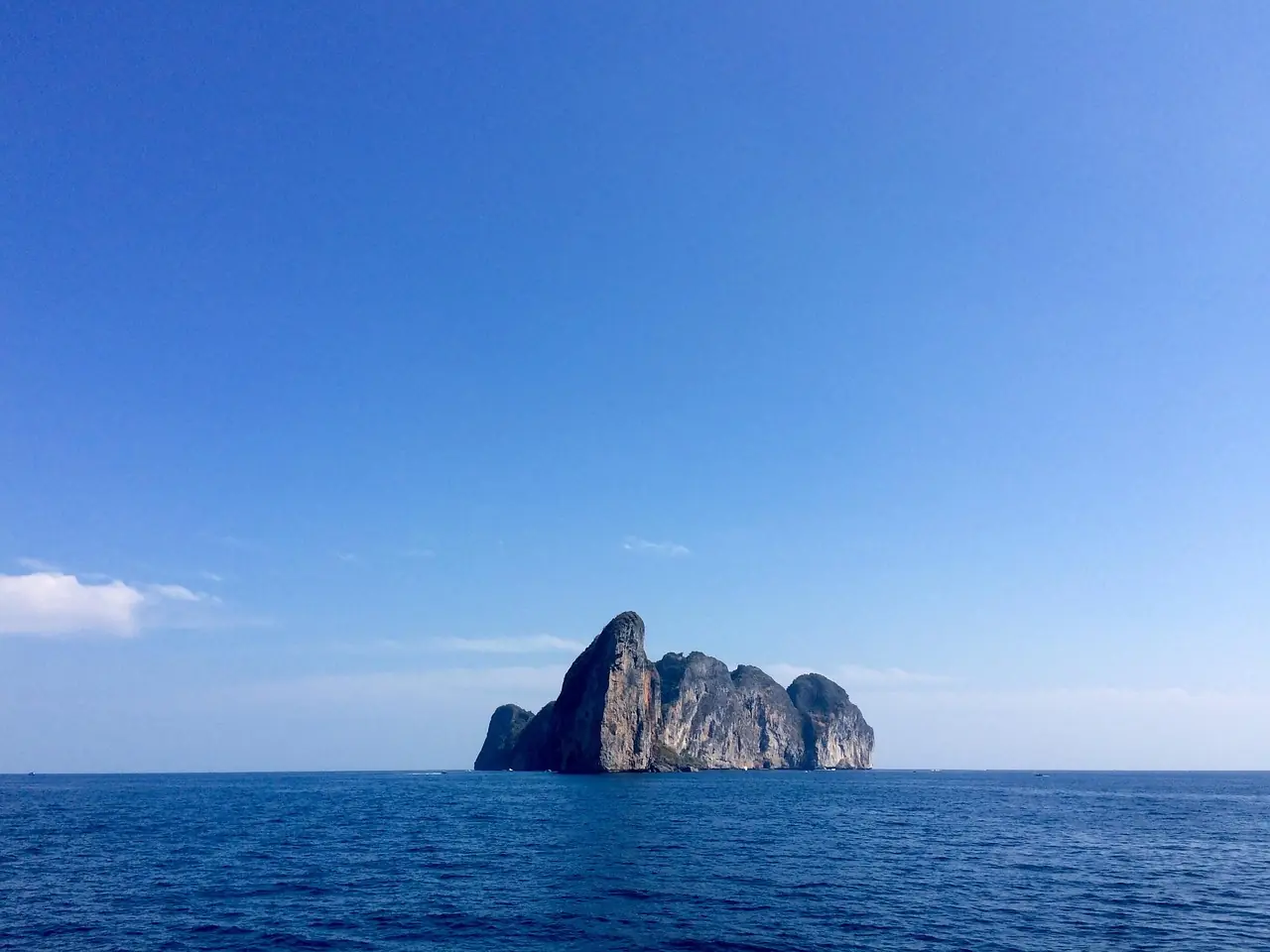 Low sandy island with a shallow coral reef and clear water