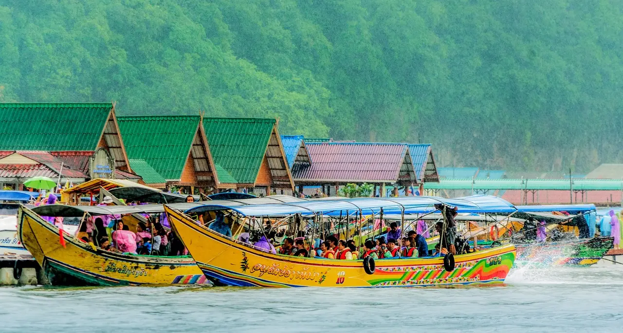 Stilt village built over the water beneath a limestone cliff