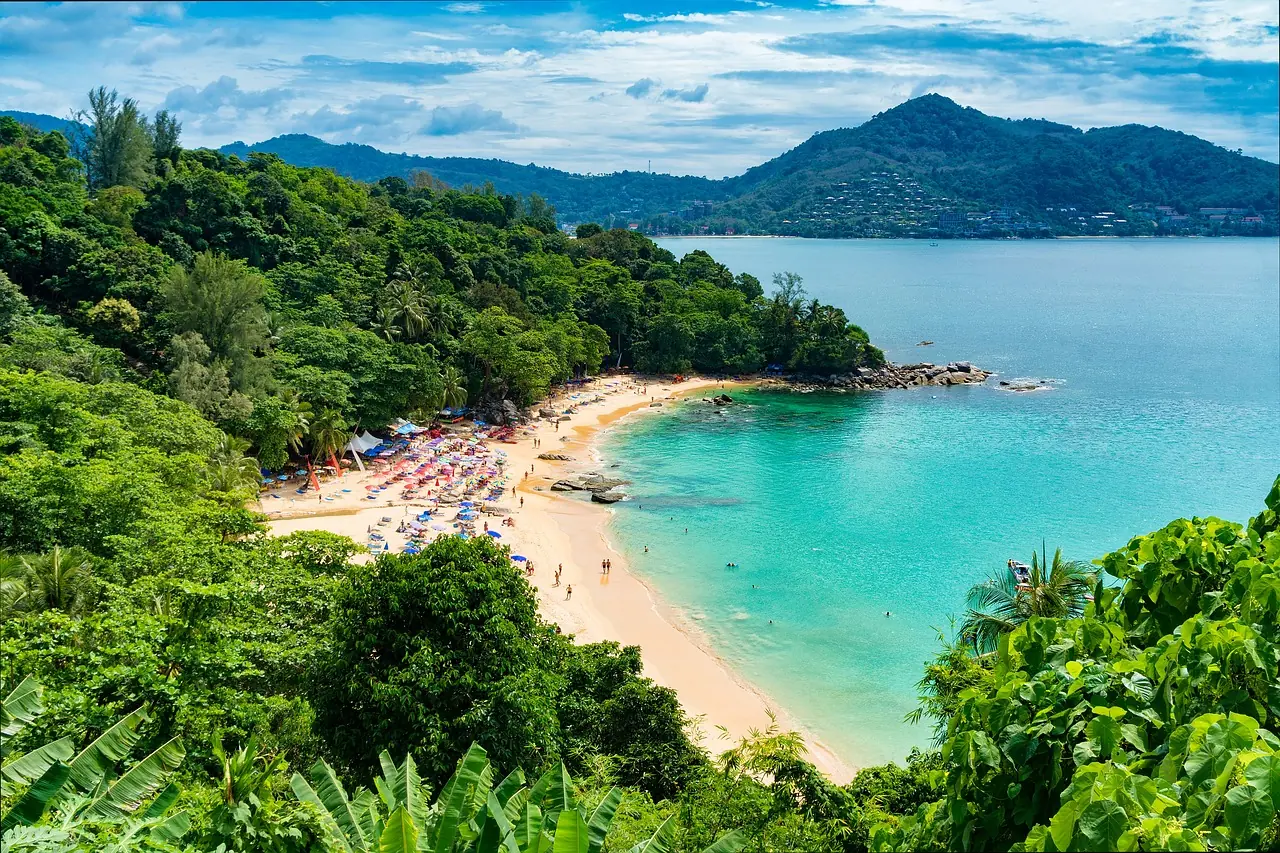 Clear turquoise bay with a white sand beach and moored boats