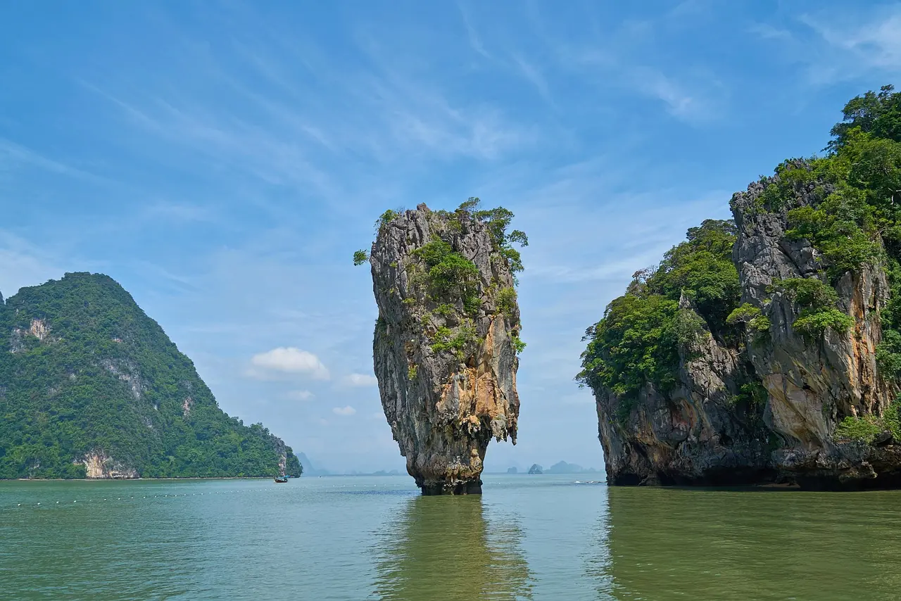 Limestone islands of Phang Nga Bay at sunset with a yacht at anchor