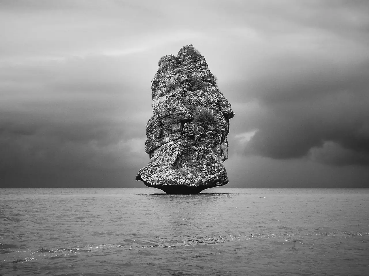 Green limestone islands under monsoon cloud in a sheltered bay