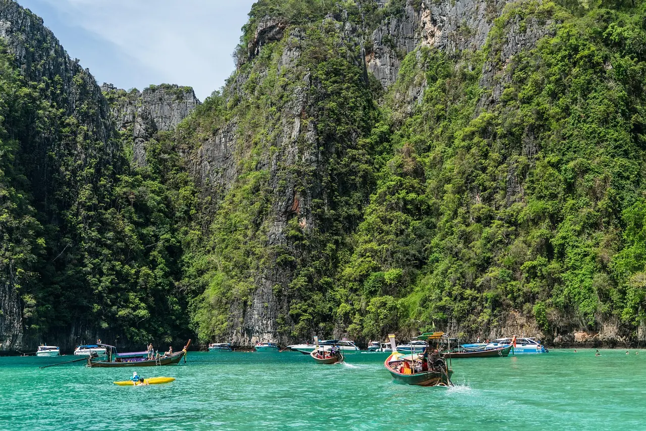 Yacht anchored off limestone cliffs in the Phi Phi islands at sunrise