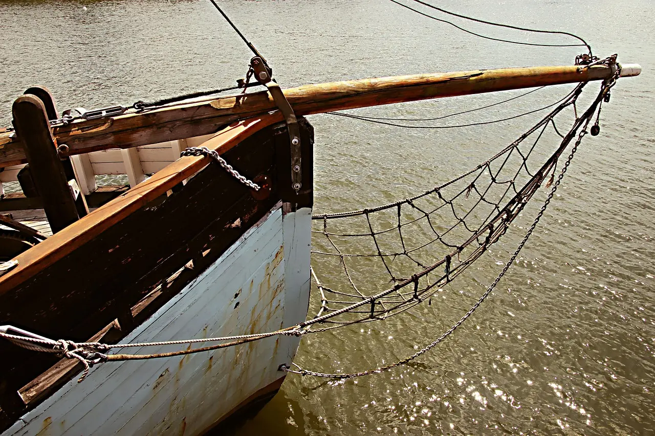 Traditional wooden motor-sailer at anchor with awnings rigged