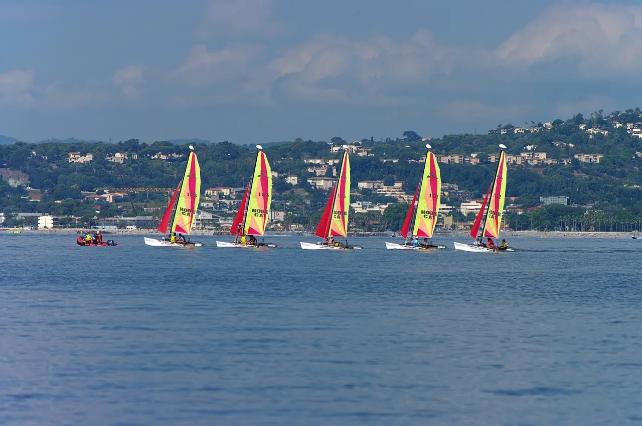 Four-cabin charter catamaran with flybridge helm at anchor