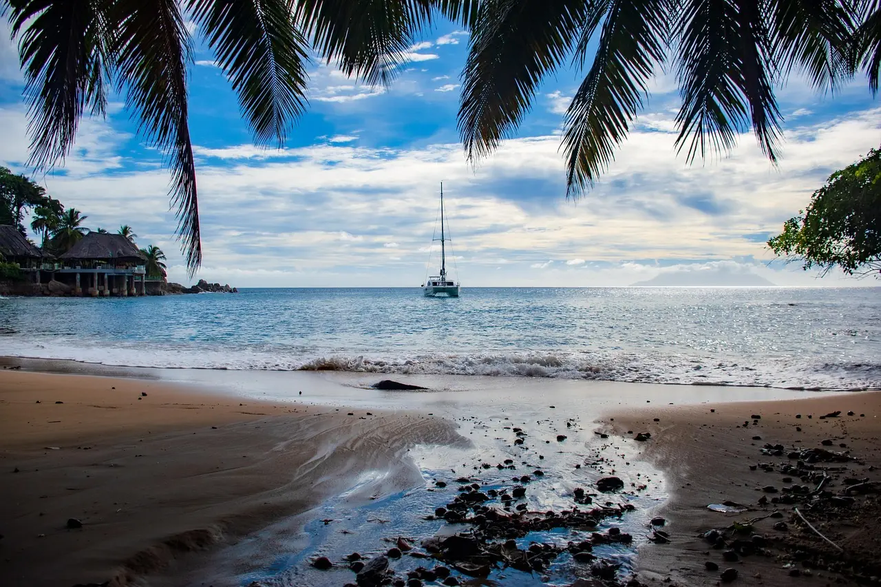 Large luxury sailing catamaran at anchor with the tender alongside